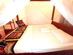 Cama blanca en habitación con dosel en Shine Breeze villa, en Ahangama