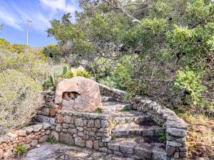 a set of stone stairs in a hill with trees at Villa Adea in Santa Teresa Gallura