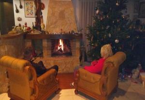 two children sitting in chairs in front of a christmas tree at Rooms Branka in Križevci +18 photos