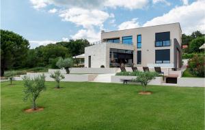 Une grande maison blanche avec des arbres dans la cour dans l'établissement Villa Calma Istra, à Nedeščina