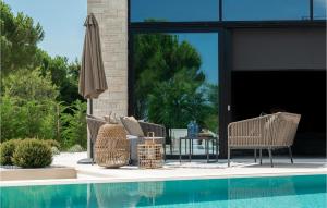 un patio avec des chaises et un parasol à côté d'une piscine dans l'établissement Villa Calma Istra, à Nedeščina 32 autres photos