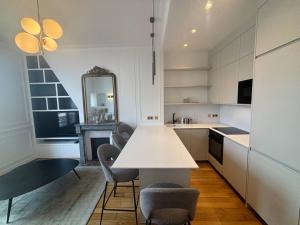 a kitchen with a table and chairs and a mirror at Le Splendide au Centre ville de Versailles in Versailles
