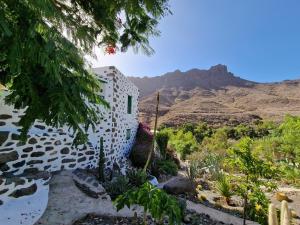 a building with a mountain in the background at Small cozy house Susana in Mogán