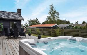 a hot tub on a patio with a table and chairs at Lovely Home In Juelsminde With Wifi in Juelsminde