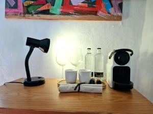 a table with a lamp and wine glasses on it at Small cozy house Susana in Mogán