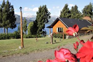 a log cabin with a view of the water at Costa Traful in Villa Traful +5 photos