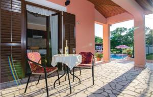 un tavolo con bottiglie di vino e sedie su un patio di Holiday Home Vinez V a Vinež