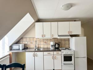a kitchen with white cabinets and a sink at Spacious and cenral apartment in Visby