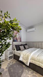 a bedroom with a bed and a plant in it at Frederica Luxury Apartments in Lagyná