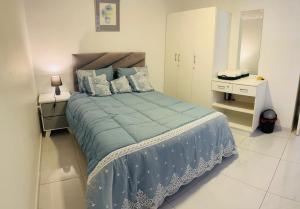 a bedroom with a large bed with blue sheets and pillows at The MK House in Cape Town