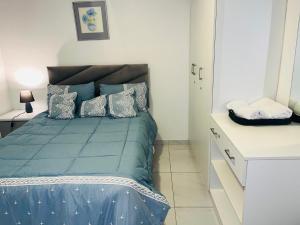 a bedroom with a blue bed and a white cabinet at The MK House in Cape Town