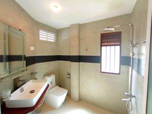 Un baño con un inodoro blanco y un lavabo. en Shine Breeze villa, en Ahangama