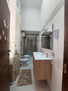 a bathroom with a sink and a toilet and a mirror at Tarantè Apartment in Naples