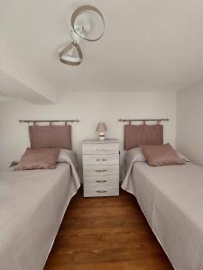 two beds sitting next to each other in a bedroom at Tarantè Apartment in Naples