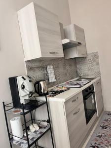 a small kitchen with a stove and a microwave at Tarantè Apartment in Naples +7 photos