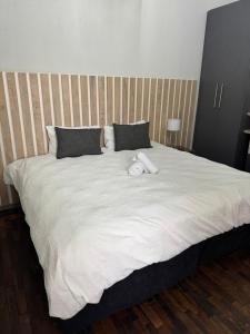 a large white bed with a stuffed animal on it at Kioma Guest House in Mokopane