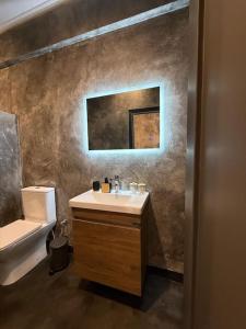 a bathroom with a sink and a toilet and a mirror at Central luxury apartment in Patra +19 photos