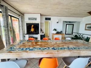 a room with a large table with chairs and a fireplace at Clearwater view in Cape Town