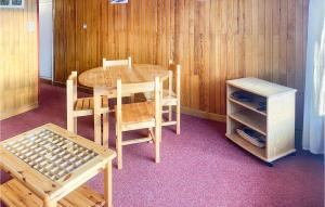 ein Holztisch und Stühle und ein Tisch und ein Schrank in der Unterkunft Cozy Apartment In Orcières With Wifi in Orcières