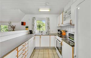 a kitchen with white cabinets and a window at Stunning Home In Ringkøbing With Sauna in Søndervig