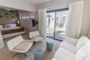 a bedroom with a bed and a living room at Waveren's Nest in Cape Town +44 photos