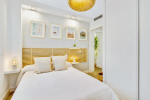 a bedroom with a large white bed with white pillows at Brasil 104 in Torremolinos +35 photos