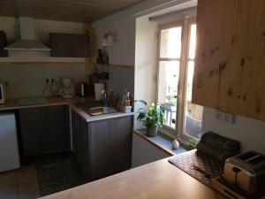 a kitchen with a counter and a sink and a window at La Petite Maison du Gardien in Sainte-Agnès