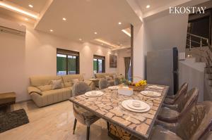 una sala de estar con una mesa y un sofá en EKOSTAY - Ivana Villa, en Lonavala