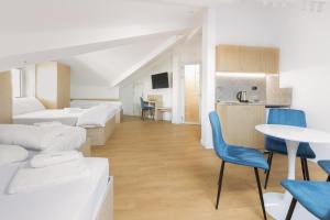 a room with white beds and a table and chairs at Millennia Hotel in Sofia