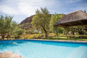 a swimming pool with a gazebo and a picnic table at Bushman Valley in Prince Albert