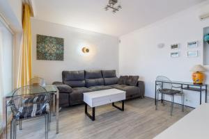 una sala de estar con un sofá y una mesa en Increíble terraza vista al mar, wifi y parking, en Torremolinos