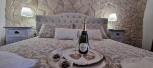 a bed with a bottle of wine and two glasses at La casa di Agnese in Fiuggi