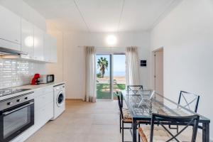 una cucina con tavolo e una sala da pranzo con vista sull'oceano di La Casa del Caballo ad Adeje