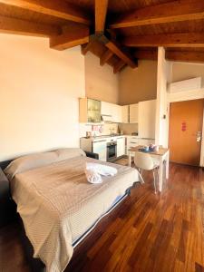 a bedroom with a large bed and a kitchen at Affori MM centro in Milan