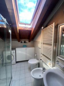 a bathroom with a skylight and a toilet and a sink at Affori MM centro in Milan
