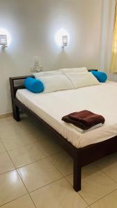 Una cama con dos almohadas azules encima. en Siri Tourist Holiday Home, en Hikkaduwa