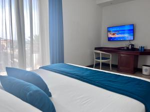 a bedroom with a bed and a desk and a television at Best Western Hotel Blumarea in Castelsardo