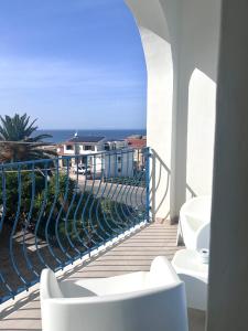 a balcony with white chairs and a view of the ocean at Best Western Hotel Blumarea in Castelsardo