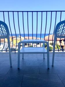a white bench sitting on a balcony with a view of the beach at Best Western Hotel Blumarea in Castelsardo
