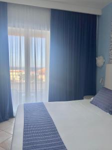 a bedroom with a bed and a large window at Best Western Hotel Blumarea in Castelsardo