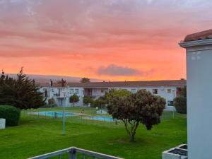 a view of a park at sunset with a building at Tranquility - walking distance to beach in Langebaan