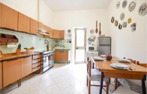 a kitchen with wooden cabinets and a table in it at Gorgeous Home In Piano Di Mommio in Piano di Mommio