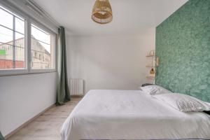 a bedroom with a white bed and a large window at Cosy cocon La Courneuve Stade de France in La Courneuve