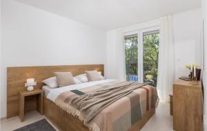 a bedroom with a large bed and a window at 2 Bedroom Beautiful Home In Kraljevica in Kraljevica
