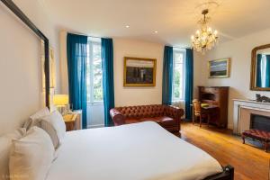 a bedroom with a bed and a couch and a fireplace at Suite Petite -Nice - SPA-JACUZZI - MASSAGE- SAUNA - 4 SAISONS - Piscine Chauffée Toute l'année - POOL VIEW- Heated Pool 800m city centre Nyons in Nyons +95 photos