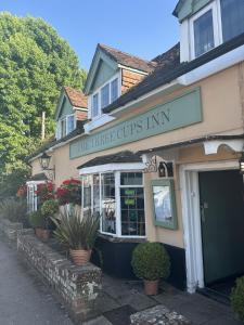 ストックブリッジにあるThe Three Cups Innの木製のカップのような看板のある店