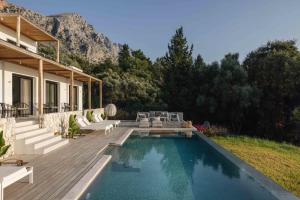 a house with a swimming pool and a deck at Villa No Worries - Where Tranquility meets Luxury in Paleros