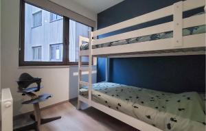 オーステンデにある2 Bedroom Cozy Apartment In Oostendeの二段ベッド2台と椅子のある寝室
