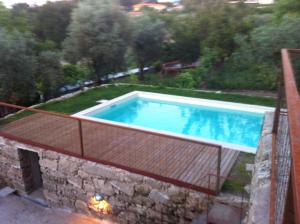 a swimming pool on top of a stone wall at Casa de Sao Cosmado in Mangualde
