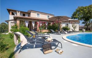 a patio with chairs and a pool and a house at Villa Astarea in Vodnjan